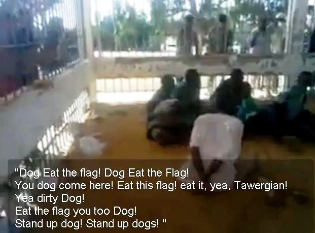 Libyan rebels tormenting a group of black Africans, locking them in a zoo-like cage and forcing them to eat the old Libyan flag.